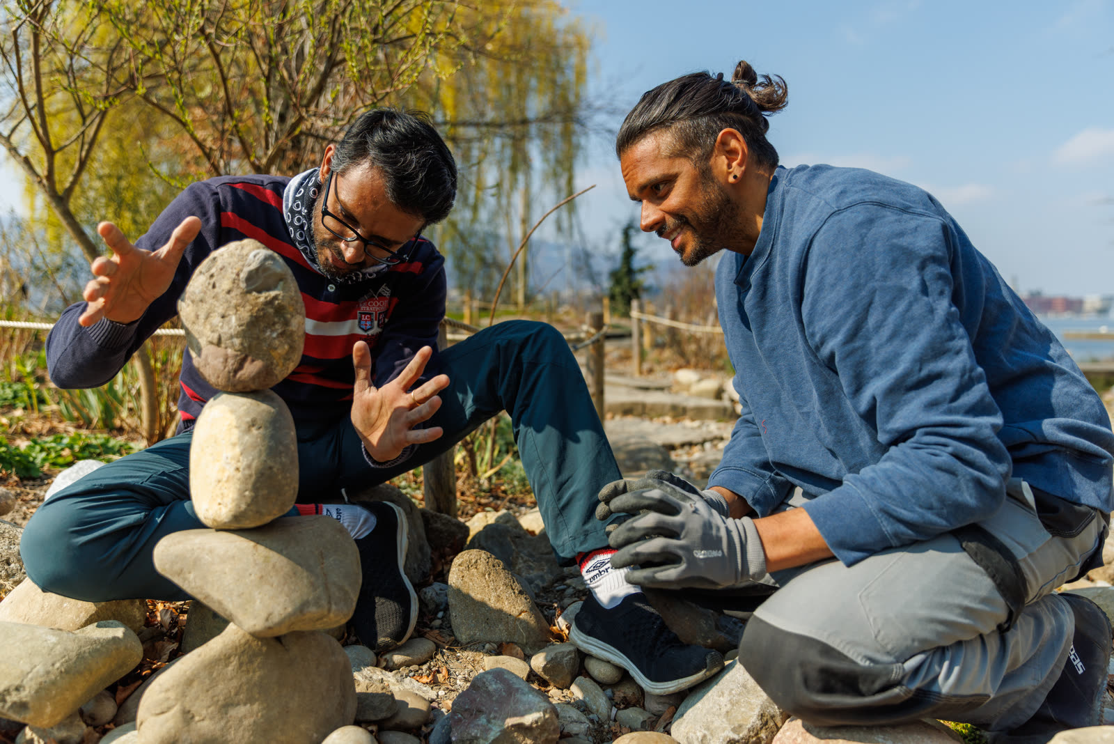 Greg coaching a participant through a balance at the lakeside stone garden