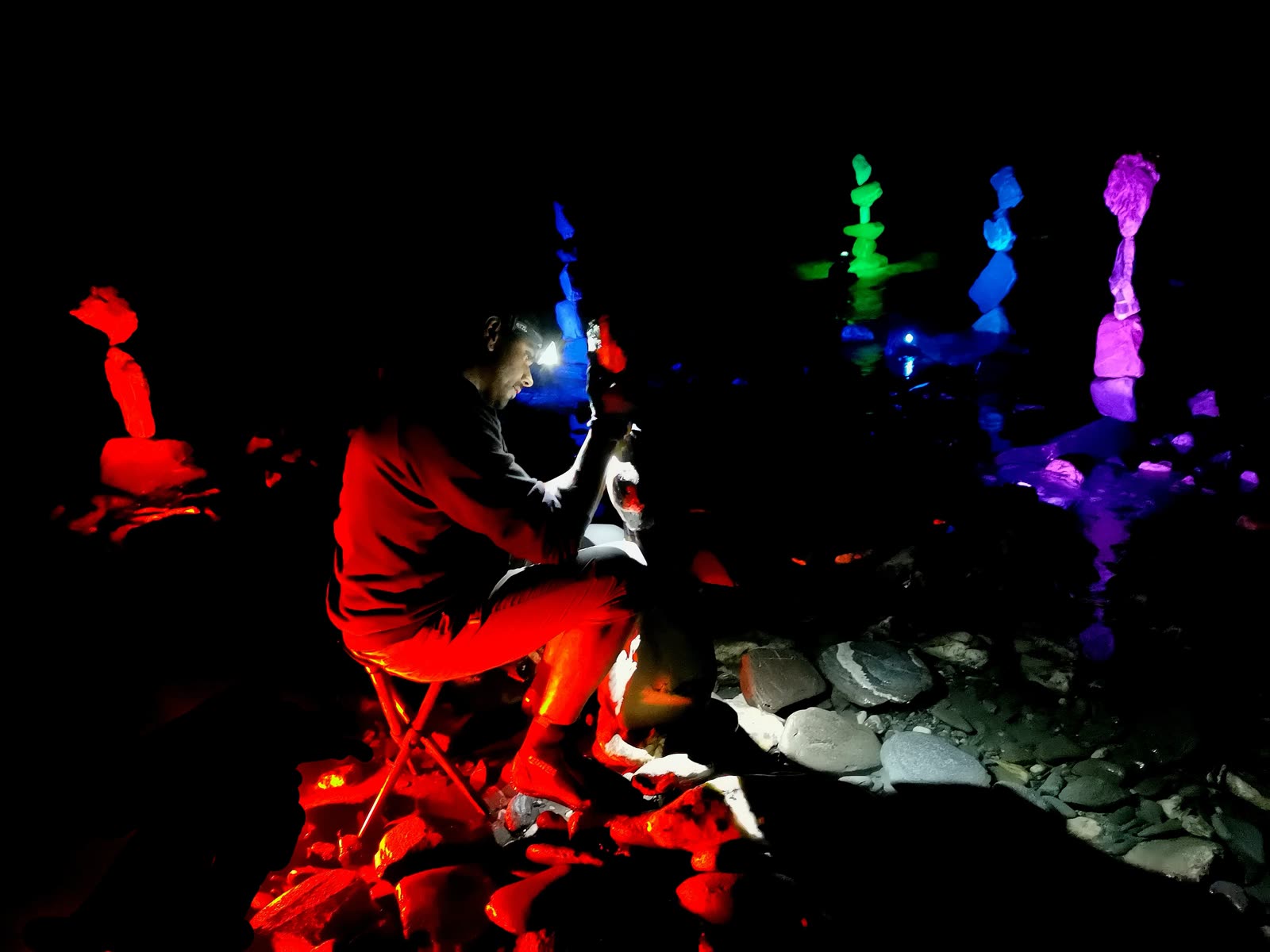 Greg working by headlamp among rainbow-lit stone towers in the Rheinschlucht