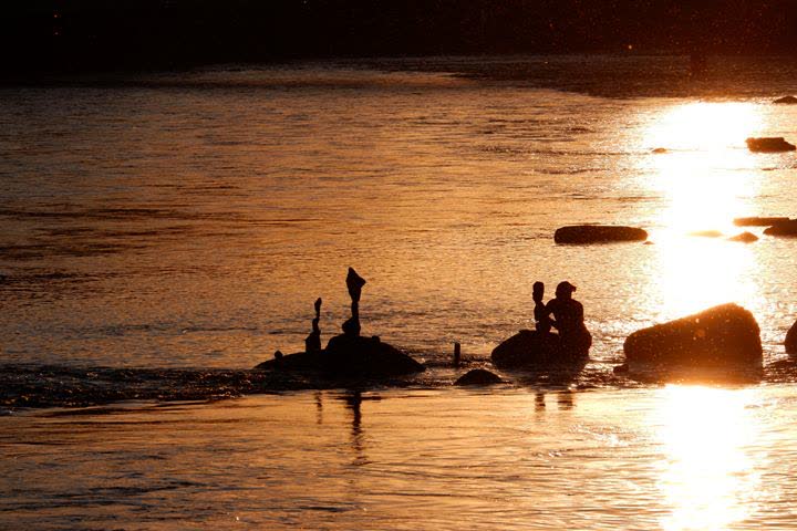 Stone stacks silhouetted on the water at sunset, GZ Wipkingen, Zürich